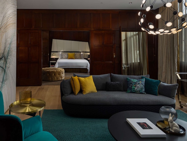 QT Sydney's dark and moody interior design featuring plush velvet couches and dark wood walls