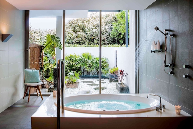 Pullman Magenta Shores Resort's deep soaking spa tub leading out to a little garden.