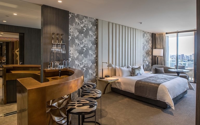 Emporium Hotel South Bank's stylish suite with private balcony, sitting area, and mini bar