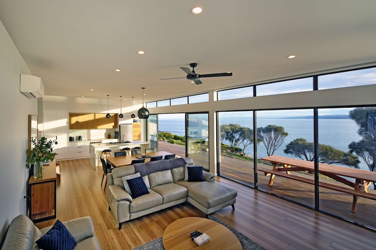 Freycinet Coastal Retreat's open plan layout and furnished deck with ocean views