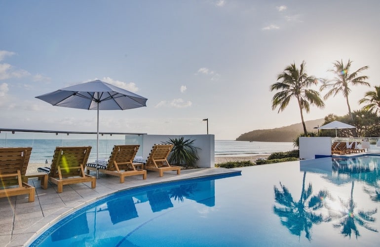 Outdoor pool with loungers and ocean view at Tingirana Noosa