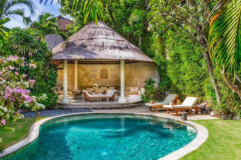 Tranquil garden with freeform pool, loungers, and gazebo at Villa Kubu