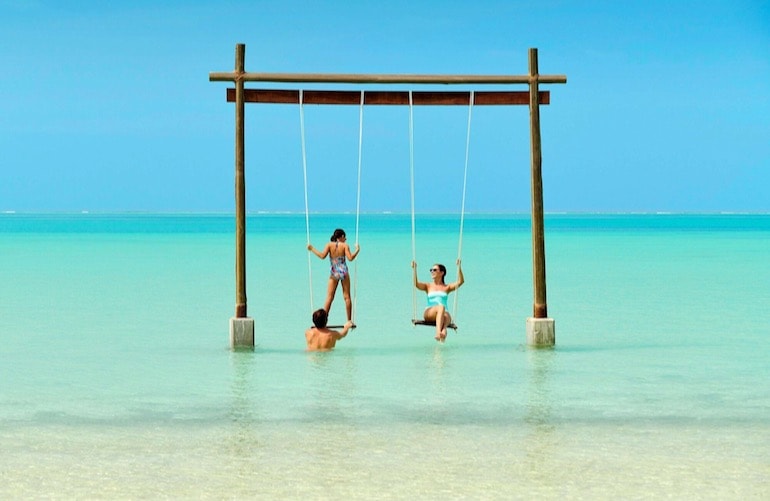 Fairmont Maldives Sirru Fen Fushi has over-water villas and child-friendly spots like this ocean swing making it one of the top family-friendly Maldives hotels